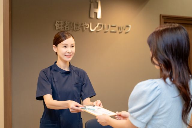 受付を行う女性スタッフと患者