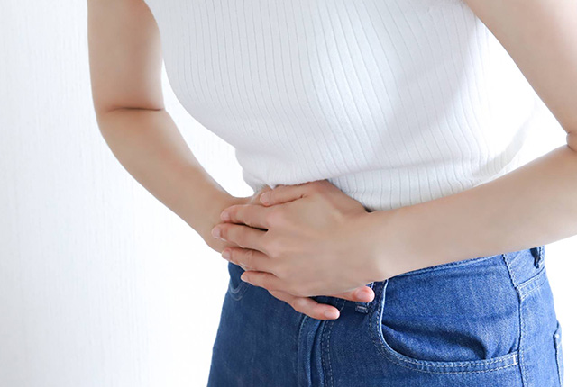 腹部を抑える女性