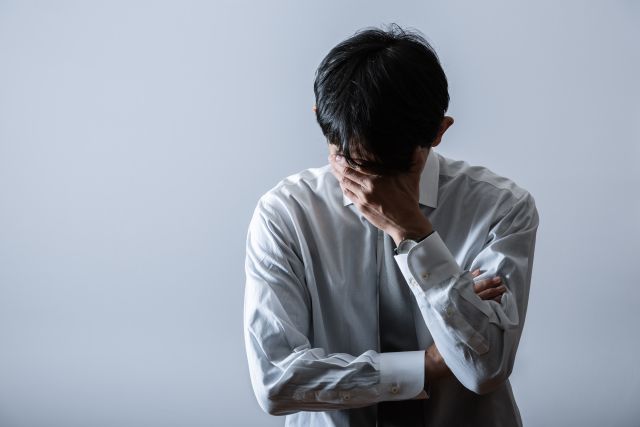 精神的に落ち込む様子の中年男性のイメージ