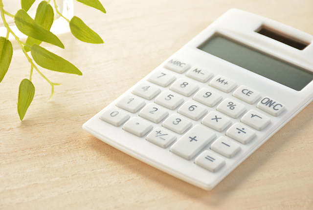 机の上にある白い電卓と植物