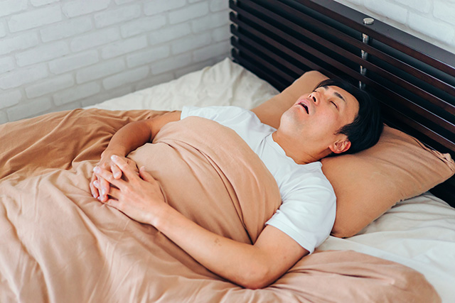 仰向けで寝ている中年男性