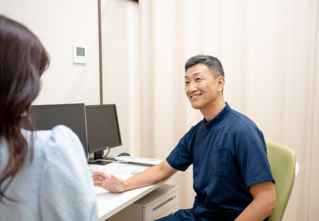 診察室で患者に説明している健都はやしクリニック院長